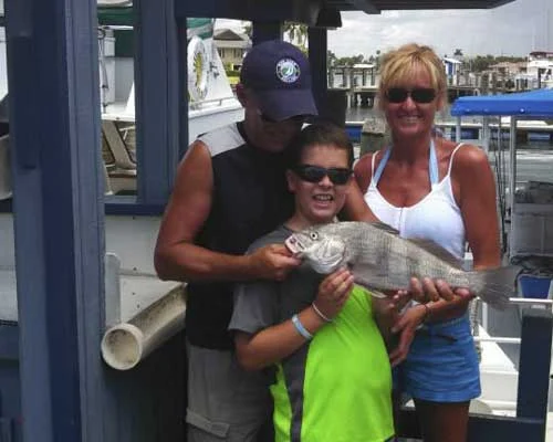A family showing off their catch at the dock
