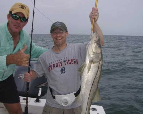 Anglers holding up a catch on the boat